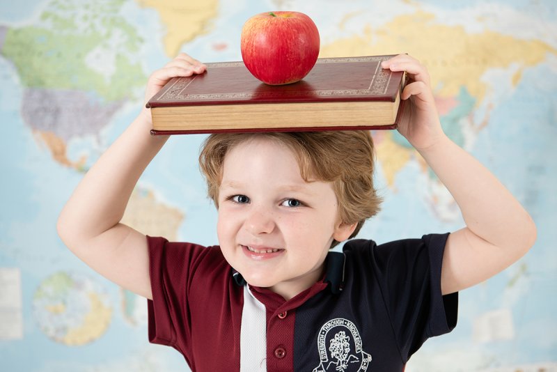 School boy with book and apple